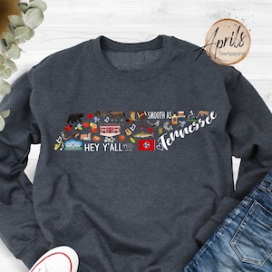 May include: A dark blue sweatshirt with a graphic of the state of Tennessee. The graphic includes the text "Smooth as Tennessee" and "Hey Y'all".