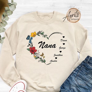 May include: A beige sweatshirt with a floral heart design and the word "Nana" inside the heart. The names Diana, George, Jonathan, and Amelia are listed below the heart.