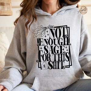 Puede incluir: Sudadera con capucha gris con un estampado gr&aacute;fico negro que dice "No hay suficiente salvia para esta mierda".