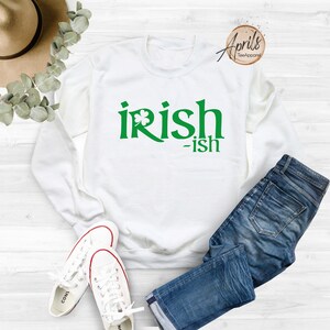 May include: White sweatshirt with green text that reads "irish-ish" with a shamrock graphic.