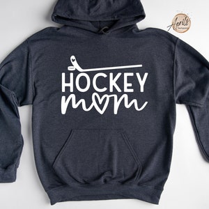 May include: A dark gray hoodie with a white graphic that says "HOCKEY mom" with a heart in the "o" of mom and a hockey stick above the text.