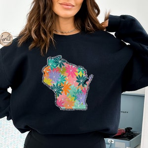 May include: Black sweatshirt with a floral design in the shape of the state of Wisconsin. The flowers are in shades of pink, orange, yellow, green, and purple.