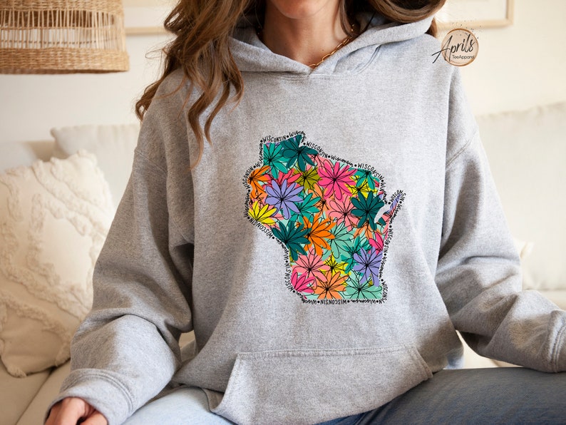 May include: A gray hoodie with a floral design of the state of Wisconsin. The flowers are in shades of pink, orange, yellow, green, and purple.