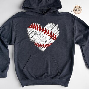 May include: A dark blue hooded sweatshirt with a white distressed baseball heart graphic. The baseball heart has red stitching.