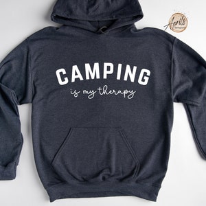 May include: A dark gray hooded sweatshirt with the text "CAMPING is my therapy" in white.