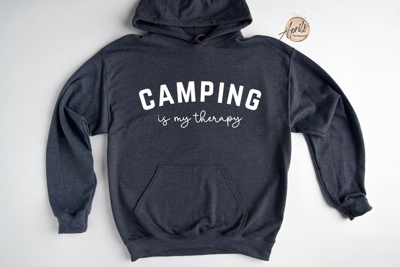May include: A dark gray hooded sweatshirt with the text "CAMPING is my therapy" in white.