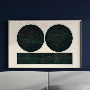 May include: A vintage star chart print in a silver frame hangs above a bed with a blue duvet and gray pillows. The room is painted a deep blue.