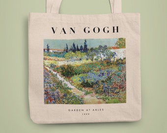May include: A white canvas tote bag with a print of Vincent van Gogh's painting "Garden at Arles" from 1888. The painting depicts a garden with a path leading through it, surrounded by trees and flowers in shades of blue, green, yellow, and orange.