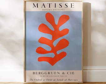 May include: A rectangular art print featuring a Matisse Papiers Découpés exhibition poster. The design displays a large, organic orange leaf-like shape centered on a light blue background, with black text including BERGGRUEN & CIE at the bottom.