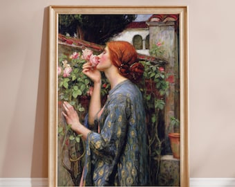 May include: A framed art print featuring a woman with red hair smelling a pink rose. She wears a blue patterned gown. The artwork is set in a garden with a stone wall and a glimpse of a building in the background.