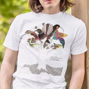 Op de afbeelding: Wit T-shirt met een kleurrijke afbeelding van vogels op een boom. De tekst op het shirt luidt "Take the leaf and now the tree can grow without the ones where we will never go."