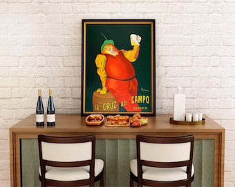 May include: A framed vintage poster featuring a person in a green hat and red tunic holding a glass of beer while leaning on a wooden barrel. The text at the bottom reads LA CRUZ DEL CAMPO SEVILLA in yellow letters against a dark green background.