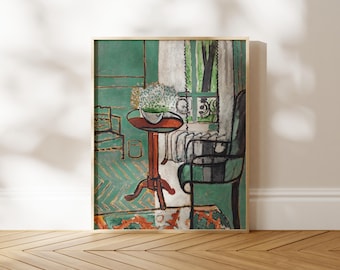 May include: A framed art print depicting an interior scene with a green wall, a round brown pedestal table holding a white bowl of flowers, a black chair, a wooden chair, and a window with white curtains overlooking a green outdoor area.