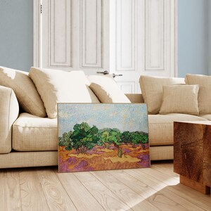 a living room with a couch and a painting on the floor