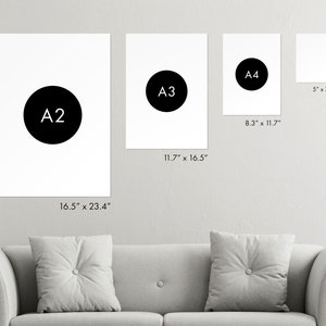 Puede incluir: Una comparaci&oacute;n de diferentes tama&ntilde;os de papel, etiquetados como A2, A3 y A4, con sus dimensiones correspondientes en pulgadas. Los tama&ntilde;os se muestran en una pared blanca con un sof&aacute; gris en primer plano.