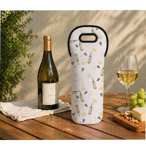 Peut inclure: Une bouteille de vin, un verre de vin et un sac à bouteille de vin avec un motif de bouteilles de vin, de raisins et de fromage sur une table en bois. Une bouteille de vin est à côté du sac. Un petit plateau en bois avec du fromage et des crackers est également sur la table.