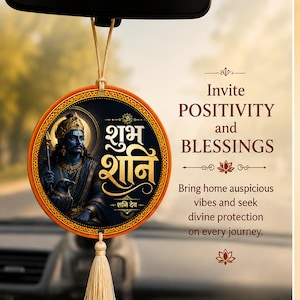 May include: A circular car hanging ornament featuring an illustration of Shani Dev in blue tones, a black background, and gold Hindi text. The ornament has an orange border, a beige hanging cord, and a matching beige tassel at the bottom.