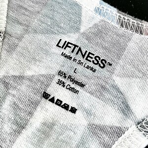May include: A white tag with black text that reads "LIFFTNESS&trade; Made in Sri Lanka L 65% Polyester 35% Cotton" and a set of care instructions symbols.