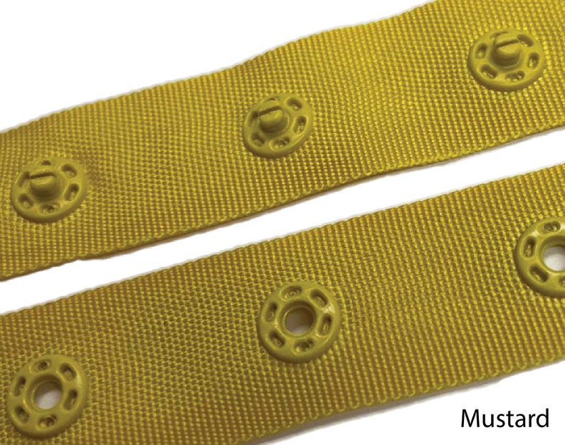 May include: Close-up of yellow fabric with a row of yellow plastic snap buttons. The fabric has a woven texture. The text "Mustard" is visible at the bottom of the image.