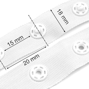 May include: White fabric tape with white plastic snaps. The tape is 15 mm wide and 20 mm long. The snaps are 18 mm in diameter.