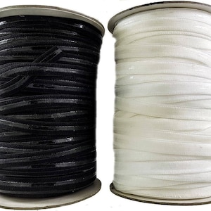 May include: Two spools of elastic ribbon, one black and one white. The ribbon is wound around cardboard spools.