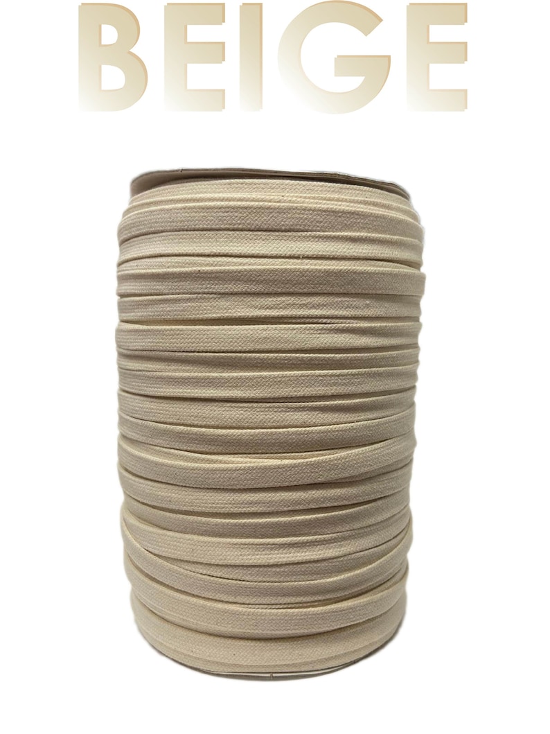 Pu&ograve; includere: Un rotolo di cordoncino elastico in cotone beige. Il cordoncino &egrave; avvolto strettamente su un rotolo di cartone.
