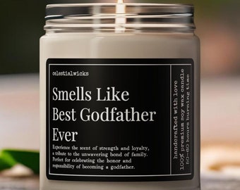 May include: A beige candle with a black label that reads "Smells Like Best Godfather Ever". The label also includes the text "Experience the scent of strength and loyalty, a tribute to the unwavering bond of family. Perfect for celebrating the honor and responsibility of becoming a godfather." The candle is lit and sitting on a wooden surface.