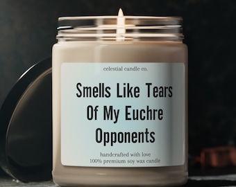May include: A beige soy wax candle with a label that reads "celestial candle co. Smells Like Tears Of My Euchre Opponents handcrafted with love 100% premium soy wax candle".