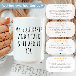 May include: White ceramic mug with the text "MY SQUIRRELS AND I TALK SHIT ABOUT YOU" in black. The mug is held by a person. The image also includes customer reviews.