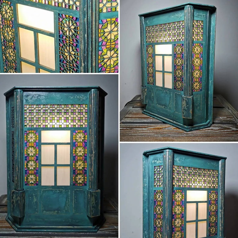 K&ouml;nnte beinhalten: Eine tealblaue Holzlampe mit einem Buntglasfenster-Design. Die Lampe hat ein Licht im Inneren, das das Buntglas beleuchtet.