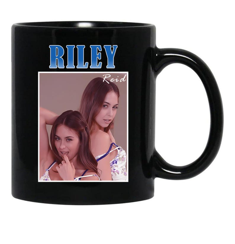 May include: Black ceramic mug featuring a photograph of two women. The mug has the name "RILEY" in blue text at the top, with "Reid" below. The mug's handle is on the right side.