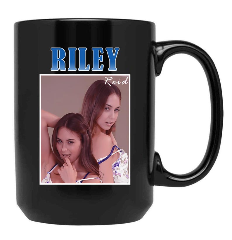 May include: Black ceramic mug featuring the name "RILEY" in blue text above a photo of a woman. The photo is in a white frame and includes the name "Reid". The mug has a large handle.
