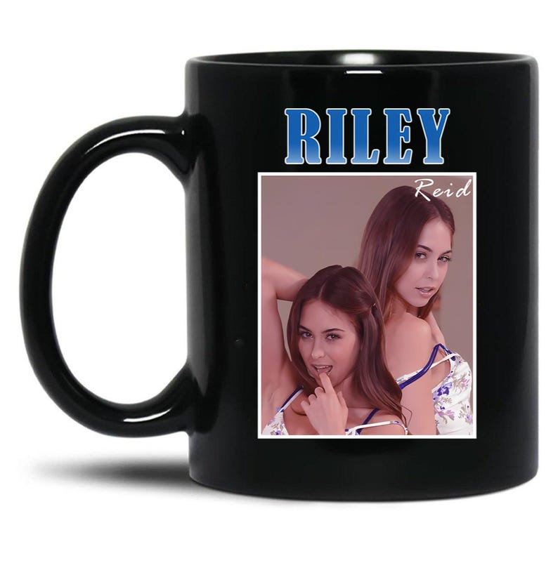 May include: Black ceramic mug featuring the name "RILEY" in blue text. The mug displays a photo of two women, with the name "Reid" printed above the image. The mug has a curved handle.