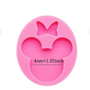 May include: Pink silicone mold in the shape of a mouse head with a bow. The mold is round with two circular ear shapes and a bow at the top. The text "4cm=1.57inch" is printed on the mold.
