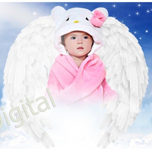 May include: A baby wearing a pink hooded towel with a white Hello Kitty design on the hood. The baby is surrounded by white angel wings and is sitting on a cloud in front of a blue sky with white stars.