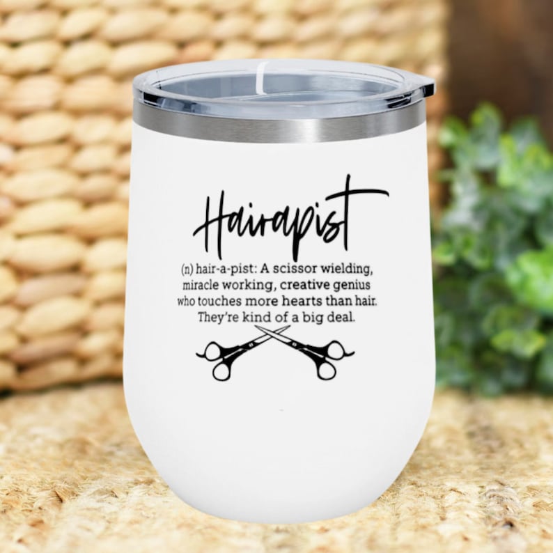 May include: White stainless steel tumbler with a black and white design that reads "Hairapist (n) hair-a-pist: A scissor wielding, miracle working, creative genius who touches more hearts than hair. They're kind of a big deal."