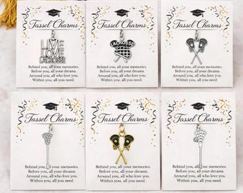 May include: Six graduation tassel charms with lacrosse themes. Each charm is attached to a card with the words "Tassel Charms" and a graduation cap design. The charms include lacrosse sticks, lacrosse nets, and the words "Live Love Lacrosse".