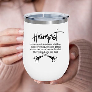 May include: White stainless steel tumbler with a black and white design that says "Hairapist (n) hair-a-pist: A scissor wielding, miracle working, creative genius who touches more hearts than hair. They're kind of a big deal."