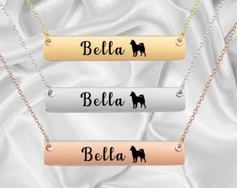 May include: Three gold, silver, and rose gold bar necklaces with the name "Bella" and a silhouette of a dog engraved on each.