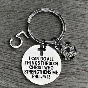 May include: Silver keychain with a soccer ball charm, a cross charm, and a round tag that reads "I can do all things through Christ who strengthens me Phil. 4:13".