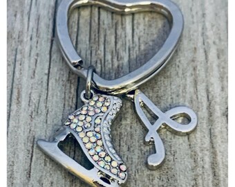 May include: A silver heart-shaped keychain with a sparkling ice skate charm and a silver letter 'A' charm.