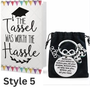 May include: A white ceramic mug with a black handle and the text "But First, Coffee" in a black, handwritten-style font. The mug is on a white surface.