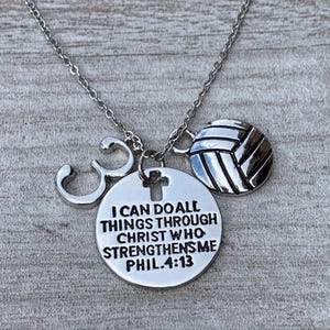 May include: Silver necklace with a volleyball charm, a cross charm, a number 3 charm, and a round charm with the text "I can do all things through Christ who strengthens me Phil. 4:13".