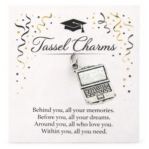 May include: A silver laptop charm hangs from a card that reads "Tassel Charms." The card has a graduation cap graphic and celebratory confetti. The text on the card reads, "Behind you, all your memories. Before you, all your dreams. Around you, all who love you. Within you, all you need."