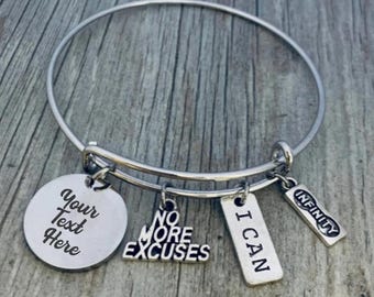 May include: Silver bangle bracelet with charms. The charms say "I Can", "No More Excuses", and "Infinity". There is also a round charm that says "Your Text Here".