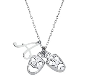 May include: A silver necklace with a letter A charm and two silver masks, one smiling and one frowning.