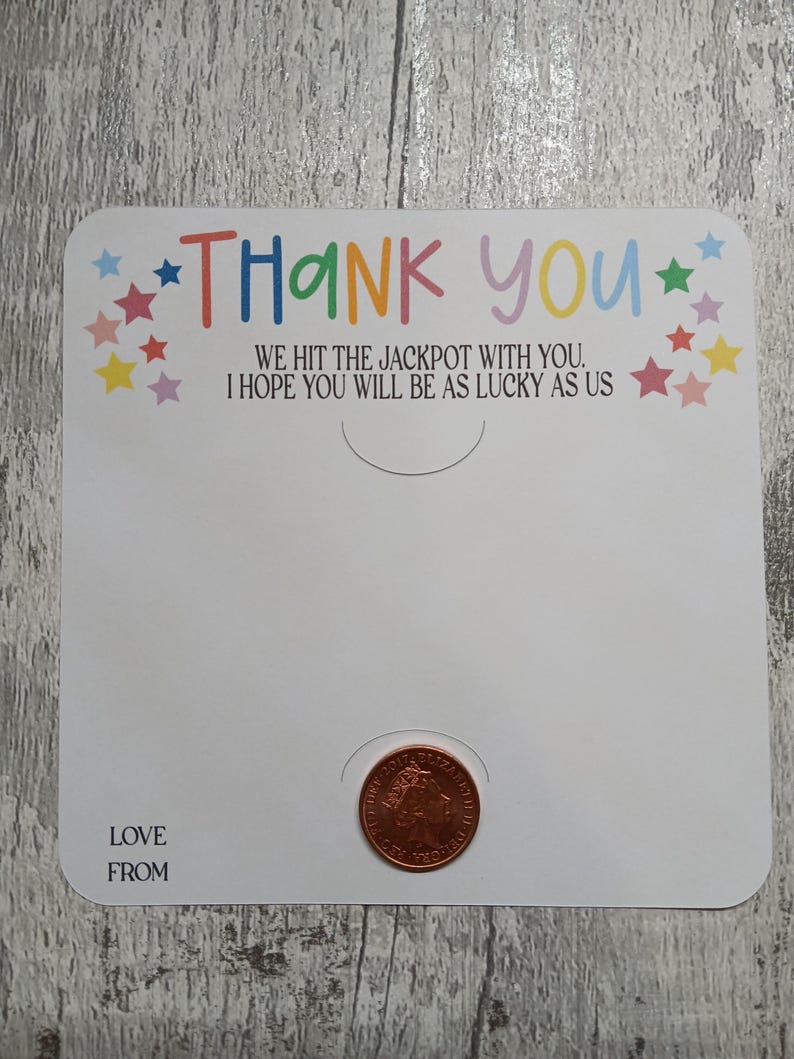 May include: A white card with the words "THANK YOU" in colorful letters and the text "WE HIT THE JACKPOT WITH YOU. I HOPE YOU WILL BE AS LUCKY AS US." A penny is placed in a circular cutout. The words "LOVE FROM" are at the bottom.