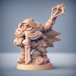 May include: A miniature figurine of a dwarf warrior wearing a hooded cloak and armor, holding a sword and a slingshot. The dwarf is standing on a base with a treasure chest and other details.