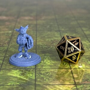 May include: A gray plastic miniature figurine of a goblin playing a musical instrument. The goblin is wearing a hat and holding a drum. The figurine is standing on a gray base. A black and gold 20-sided die is in the background.