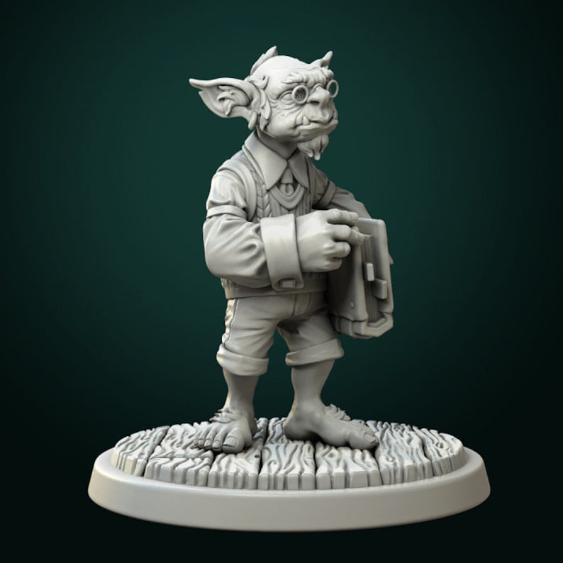 May include: A gray, sculpted figurine of a goblin wearing glasses and holding a book. The goblin is wearing a vest and pants. The figurine is standing on a wooden base.